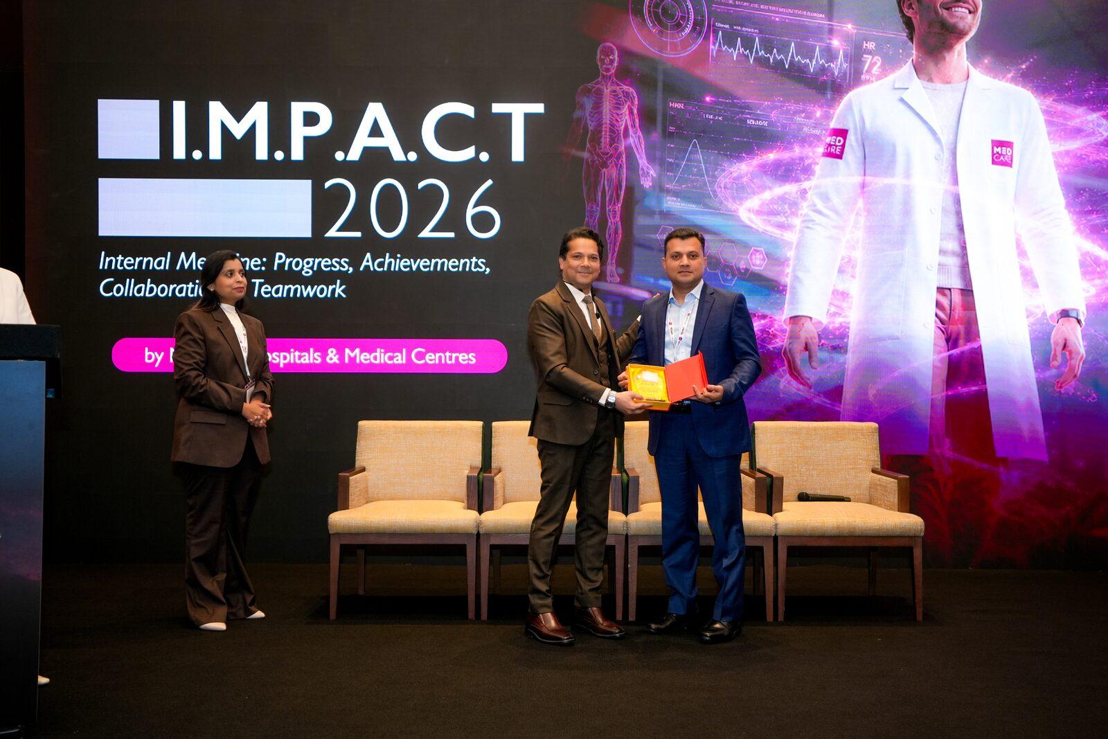 Dr. Vinod Hegade receiving speaker recognition at IMPACT 2026, Medcare Hospitals