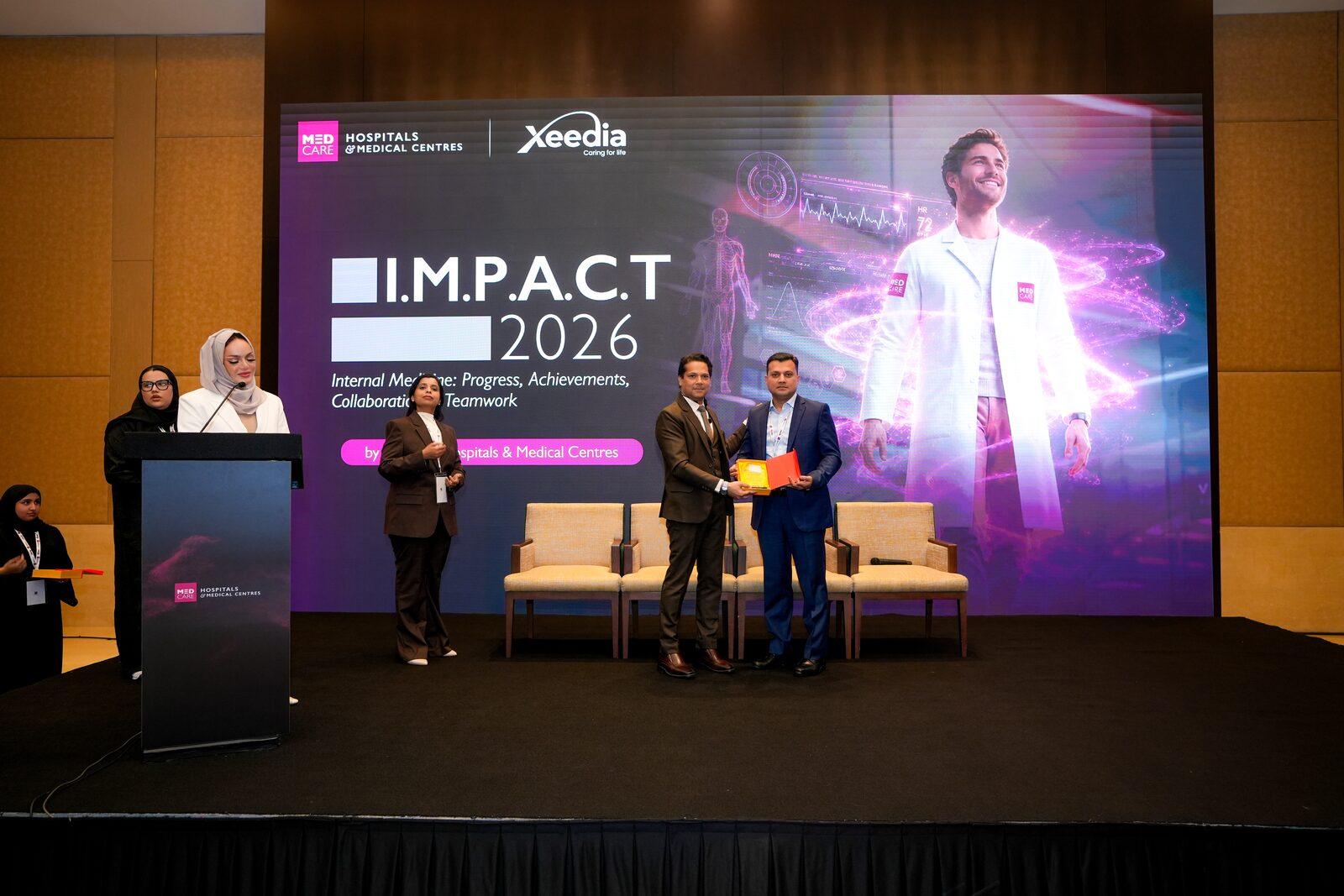 Dr. Vinod Hegade receiving a speaker token at IMPACT 2026 by Medcare Hospitals & Medical Centres